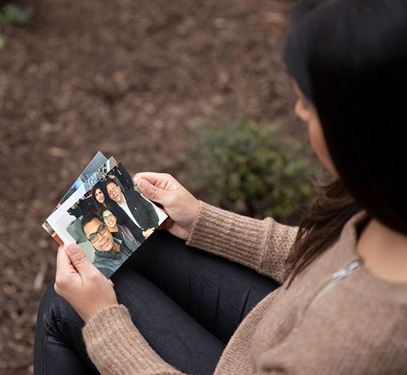 Woman looking at pictures she is holding with her hands