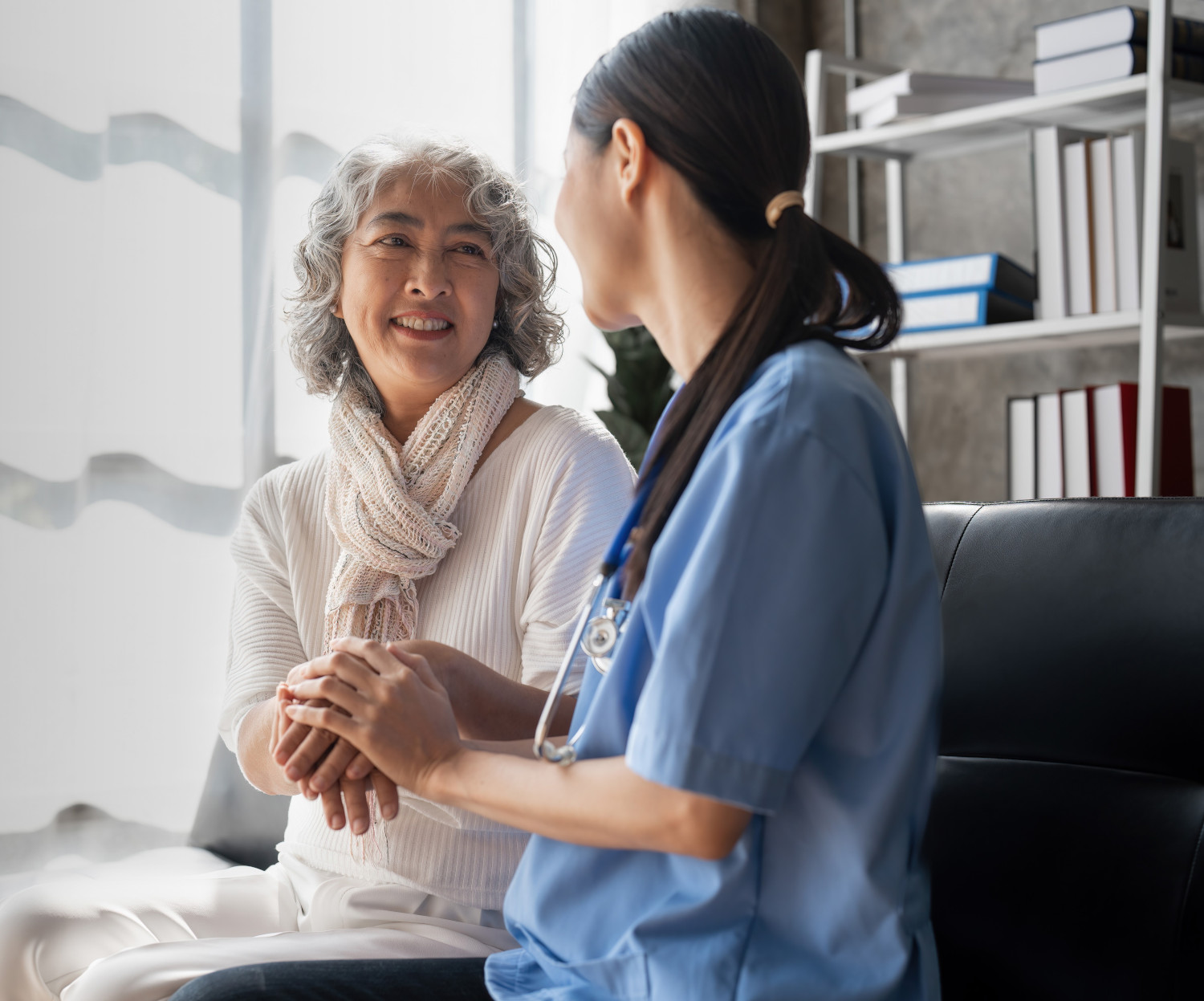 Woman and doctor holding hands and smiling